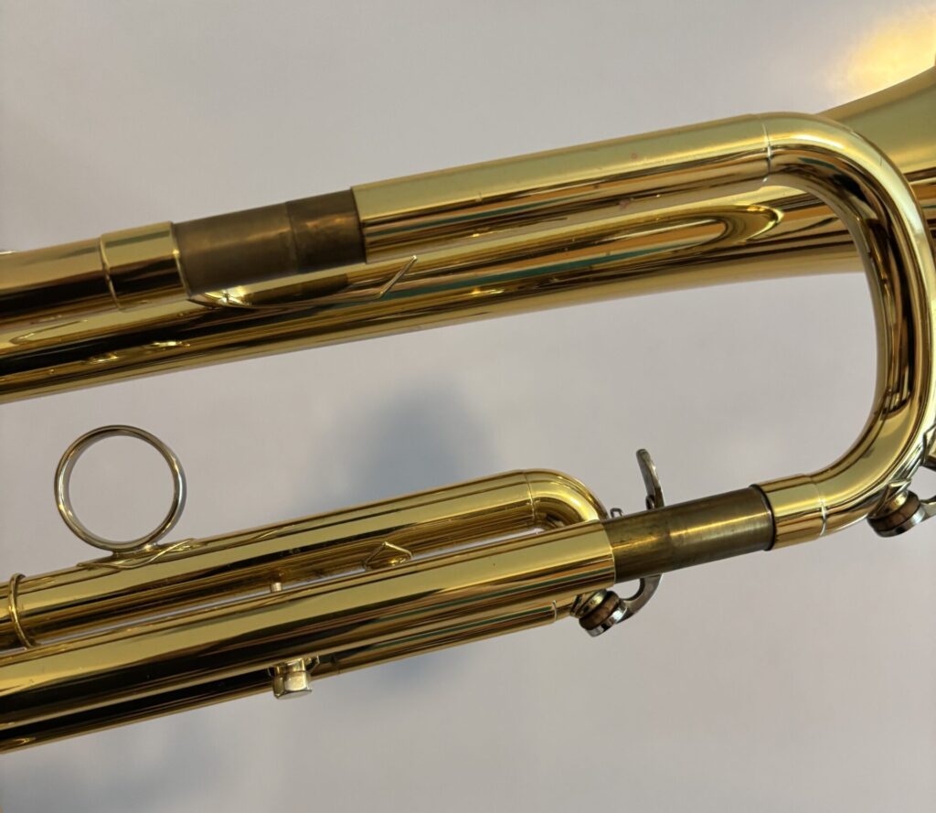 Tuning slide way out. Show on trumpet shown. Also, trombone, cornet, flugel, bass trombone, euphonium, tuba. Tuning slide too far out all the time problem. Far out.
